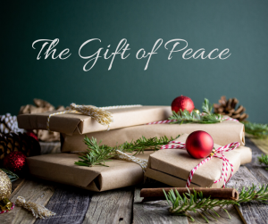 Christmas presents on wooden table with the gift of peace written above it. 